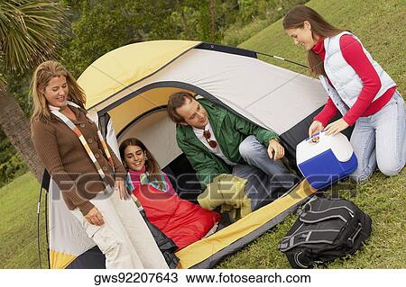 Stock Image - Mature man and a mid adult woman camping with their two daughters. Fotosearch