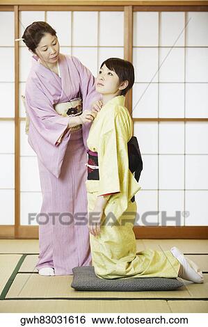 Mature woman adjusting her daughter's Kimono View Large Photo Image Stock Photograph - Mature woman adjusting her daughter's Kimono . Fotosearch