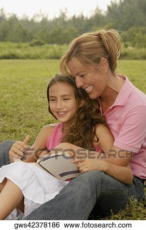 Mature woman and her daughter sitting in the park View Large Photo Image Stock Photograph - Mature woman and her daughter sitting in the park. Fotosearch