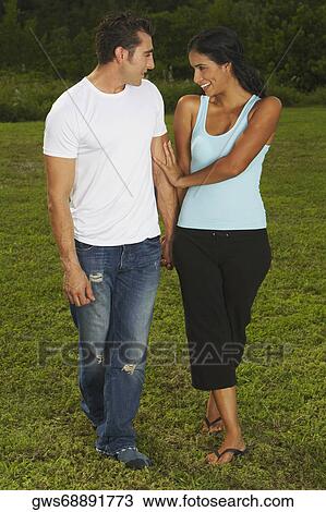 Mid adult man and a young woman looking at each other and smiling View Large Photo Image Stock Image - Mid adult man and a young woman looking at each other and smiling. Fotosearch