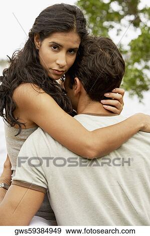 Mid adult man and a young woman embracing each other View Large Photo Image Stock Photo - Mid adult man and a young woman embracing each other. Fotosearch