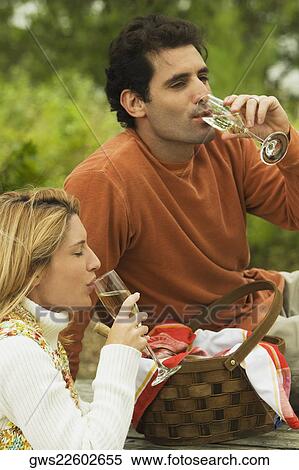 Stock Photography - Mid adult man and a young woman drinking champagne. Fotosearch
