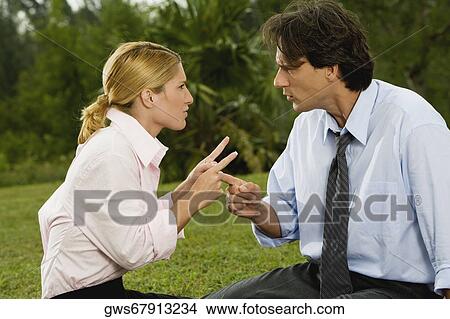 Mid adult man arguing with a young woman View Large Photo Image Picture - Mid adult man arguing with a young woman. Fotosearch