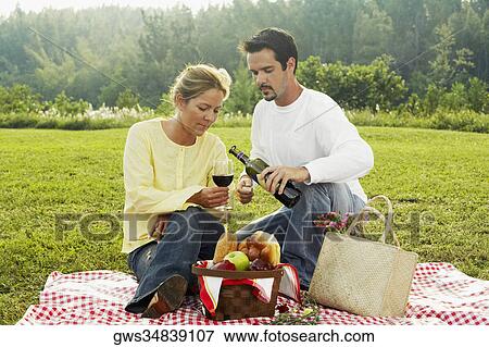 Mid adult man pouring wine into a mid adult woman's glass View Large Photo Image Stock Photo - Mid adult man pouring wine into a mid adult woman's glass. Fotosearch