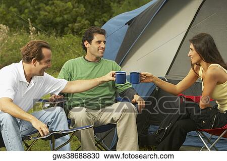 Mid adult woman and two mid adult men toasting their tea cups View Large Photo Image Stock Image - Mid adult woman and two mid adult men toasting their tea cups. Fotosearch