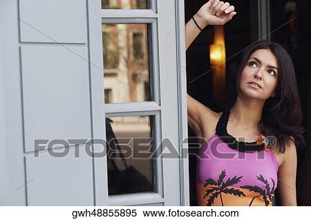 Mid adult woman leaning against a door and looking up  View Large Photo Image Stock Photography - Mid adult woman leaning against a door and looking up . Fotosearch