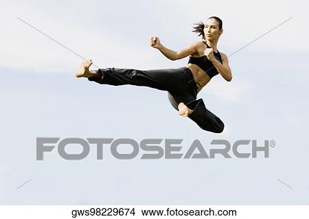 Picture - Mid adult woman practicing martial arts. Fotosearch
