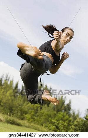 Stock Photo - Mid adult woman practicing martial arts. Fotosearch