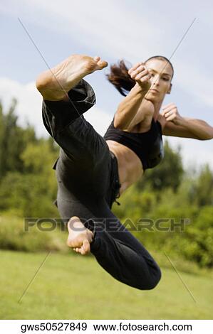 Stock Photo - Mid adult woman practicing martial arts. Fotosearch