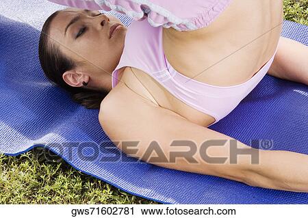 Stock Image - Mid adult woman practicing yoga. Fotosearch