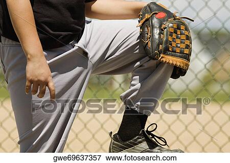 Stock Photo - Mid section view of a baseball player holding a baseball glove. Fotosearch