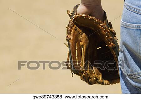 Mid section view of a baseball player wearing a baseball glove View Large Photo Image Stock Photo - Mid section view of a baseball player wearing a baseball glove. Fotosearch