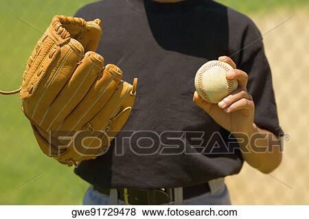 Mid section view of a baseball player holding a baseball View Large Photo Image Stock Photo - Mid section view of a baseball player holding a baseball. Fotosearch