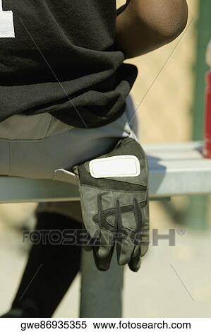 Mid section view of a baseball player sitting on a bench View Large Photo Image Stock Photography - Mid section view of a baseball player sitting on a bench. Fotosearch
