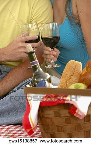 Stock Photo - Mid section view of a man and a woman toasting with champagne flutes. Fotosearch