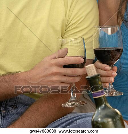 Mid section view of a man and a woman toasting with champagne flutes View Large Photo Image Stock Photo - Mid section view of a man and a woman toasting with champagne flutes. Fotosearch