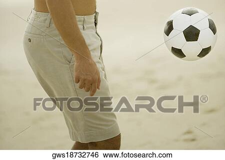Mid section view of a man playing with a soccer ball View Large Photo Image Stock Photograph - Mid section view of a man playing with a soccer ball. Fotosearch