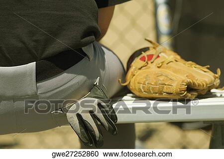 Mid section view of a person sitting on a bench with a baseball glove View Large Photo Image Stock Image - Mid section view of a person sitting on a bench with a baseball glove. Fotosearch