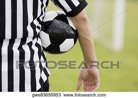 Mid section view of a referee with a soccer ball under his arm View Large Photo Image Stock Image - Mid section view of a referee with a soccer ball under his arm. Fotosearch