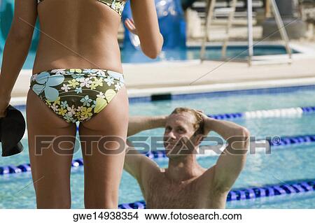 Mid section view of a woman standing in front of a mid adult man View Large Photo Image Picture - Mid section view of a woman standing in front of a mid adult man. Fotosearch