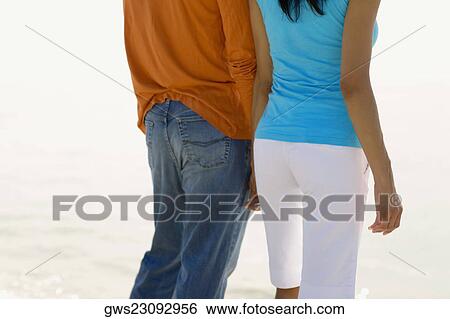 Mid section view of a young couple standing on the beach View Large Photo Image Stock Photograph - Mid section view of a young couple standing on the beach. Fotosearch