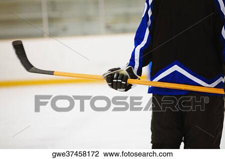 Mid section view of an ice hockey player holding an ice hockey stick View Large Photo Image Stock Image - Mid section view of an ice hockey player holding an ice hockey stick. Fotosearch