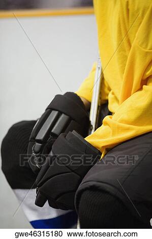 Stock Image - Mid section view of an ice hockey player in a uniform. Fotosearch