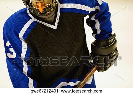Mid section view of an ice hockey player holding an ice hockey stick View Large Photo Image Stock Image - Mid section view of an ice hockey player holding an ice hockey stick. Fotosearch