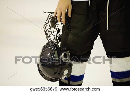 Mid section view of an ice hockey player holding a helmet View Large Photo Image Stock Photo - Mid section view of an ice hockey player holding a helmet. Fotosearch