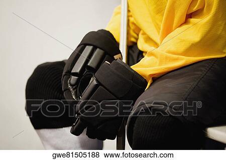Stock Photo - Mid section view of an ice hockey player in a uniform. Fotosearch