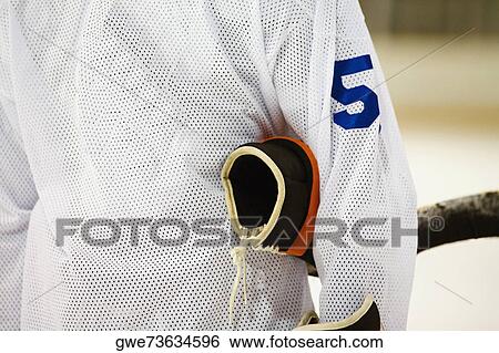 Mid section view of an ice hockey player with a glove under his arm View Large Photo Image Stock Photograph - Mid section view of an ice hockey player with a glove under his arm. Fotosearch