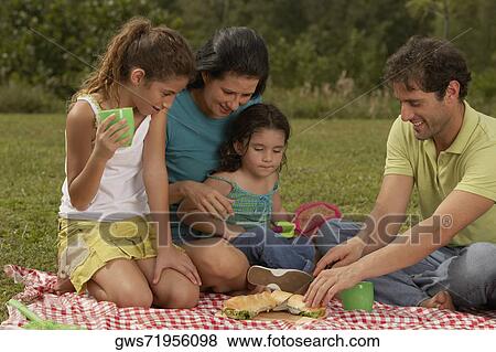 Parents and their two daughters looking at a hot dog View Large Photo Image Stock Photo - Parents and their two daughters looking at a hot dog. Fotosearch