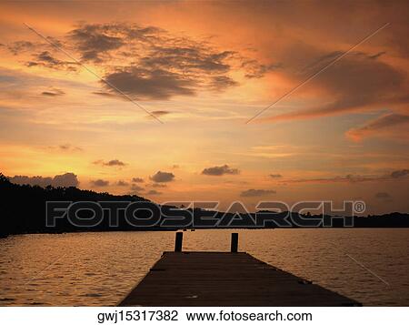 Pier in the sea at sunset View Large Photo Image Stock Image - Pier in the sea at sunset. Fotosearch
