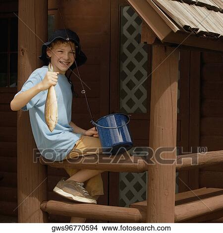 Picture - Portrait of a boy holding a trout and smiling. Fotosearch