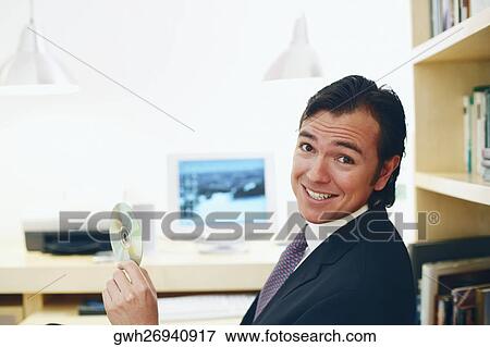 Portrait of a businessman holding a CD View Large Photo Image Stock Photo - Portrait of a businessman holding a CD. Fotosearch