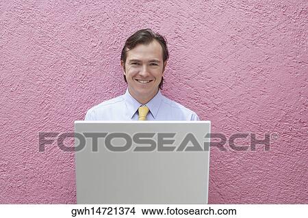 Portrait of a businessman holding a laptop View Large Photo Image Picture - Portrait of a businessman holding a laptop. Fotosearch