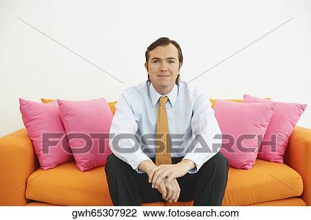 Stock Image - Portrait of a businessman sitting on a couch. Fotosearch