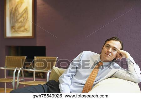 Portrait of a businessman sitting on a couch View Large Photo Image Stock Photograph - Portrait of a businessman sitting on a couch. Fotosearch