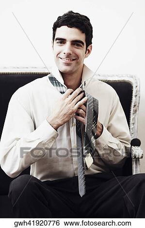 Portrait of a businessman tying his tie View Large Photo Image Stock Photograph - Portrait of a businessman tying his tie. Fotosearch
