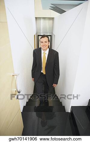 Portrait of a businessman walking up stairs View Large Photo Image Stock Photograph - Portrait of a businessman walking up stairs. Fotosearch