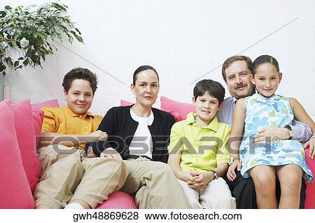 Portrait of a family sitting on a couch View Large Photo Image Stock Photo - Portrait of a family sitting on a couch. Fotosearch
