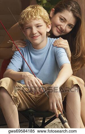 Stock Photography - Portrait of a girl and her brother holding a fishing rod. Fotosearch