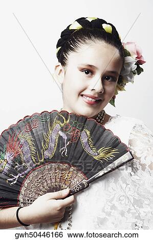 Portrait of a girl holding a folding fan and smiling View Large Photo Image Stock Photograph - Portrait of a girl holding a folding fan and smiling. Fotosearch