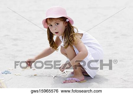 Portrait of a girl playing with a starfish on the beach View Large Photo Image Stock Photograph - Portrait of a girl playing with a starfish on the beach. Fotosearch