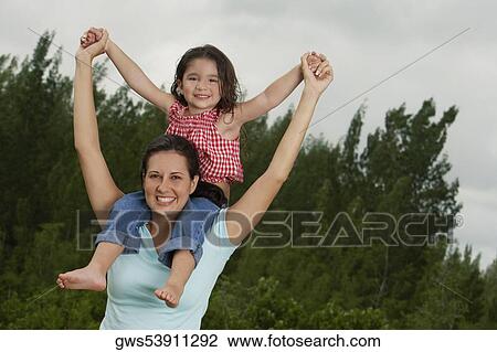 Portrait of a girl sitting on her mother's shoulder View Large Photo Image Stock Image - Portrait of a girl sitting on her mother's shoulder. Fotosearch