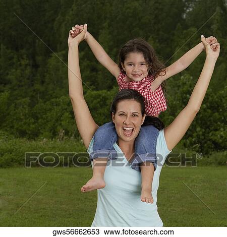 Portrait of a girl sitting on her mother's shoulders View Large Photo Image Stock Image - Portrait of a girl sitting on her mother's shoulders. Fotosearch