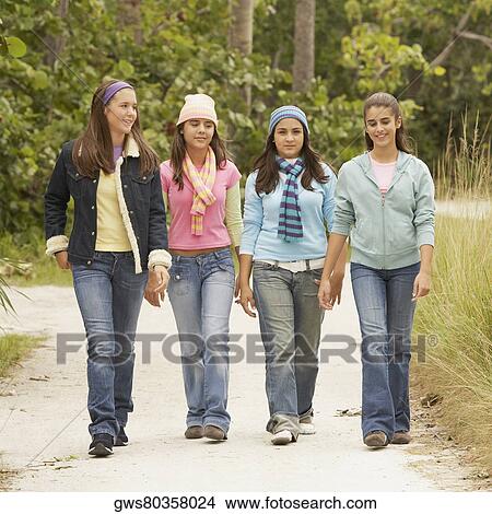 Picture - Portrait of a girl walking with her friends. Fotosearch