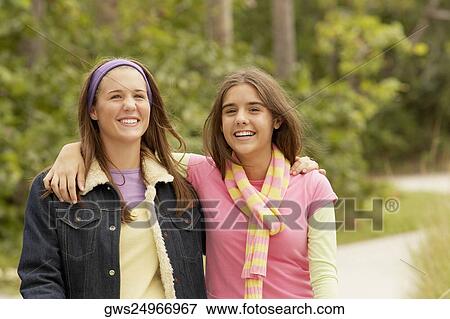 Portrait of a girl with her arm around her friend and smiling View Large Photo Image Stock Photo - Portrait of a girl with her arm around her friend and smiling. Fotosearch