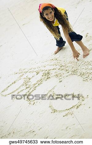 Portrait of a girl writing in sand View Large Photo Image Stock Image - Portrait of a girl writing in sand. Fotosearch