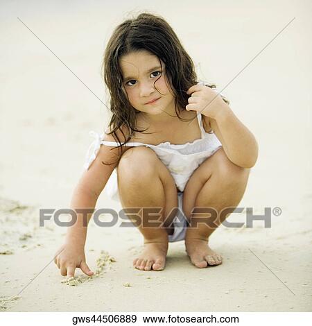 Portrait of a girl writing in sand View Large Photo Image Stock Photo - Portrait of a girl writing in sand. Fotosearch